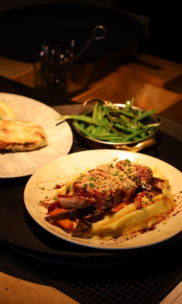 Plate of meat with mash and green beans served at the table