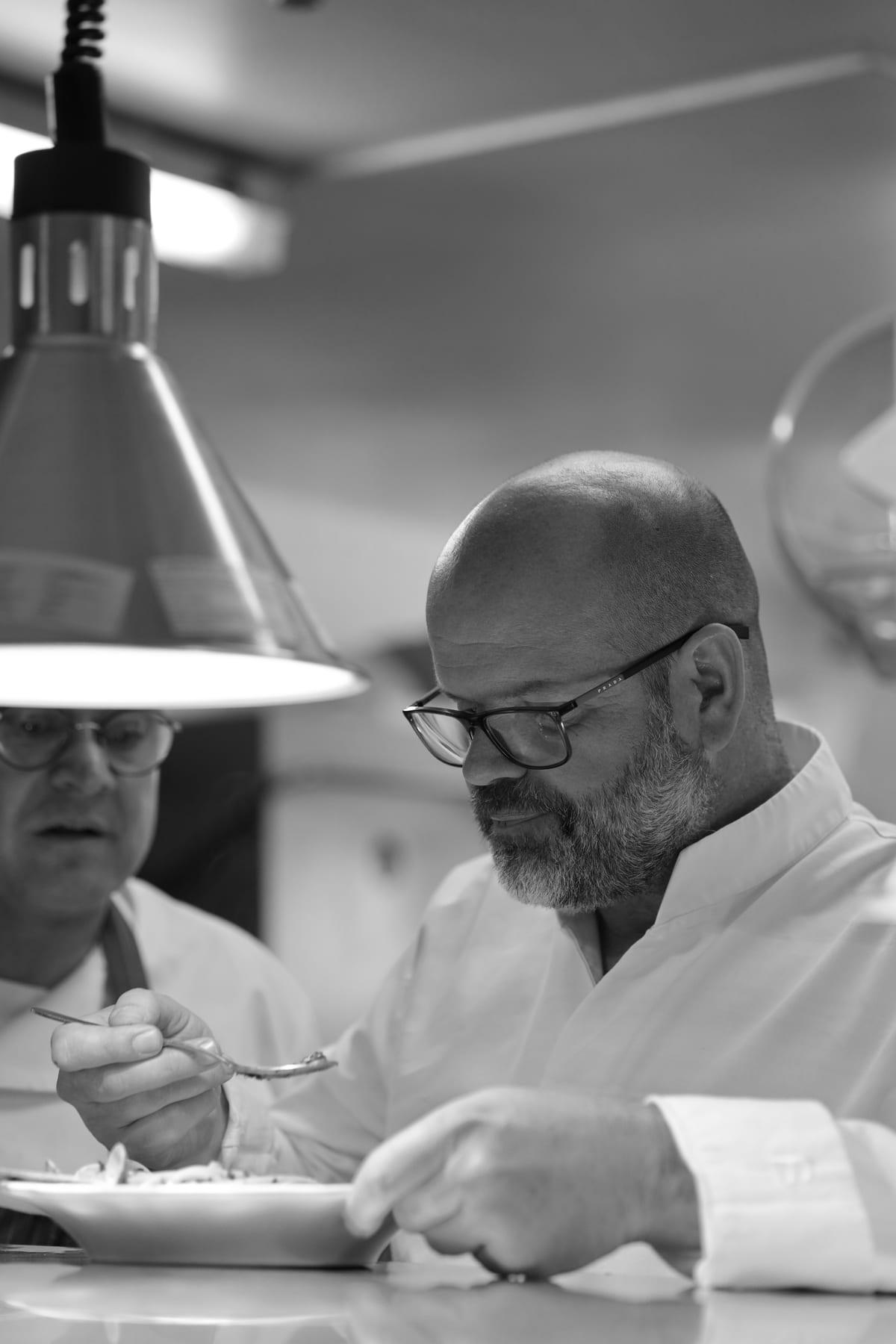 Black and white portrait of a chef plating a dish